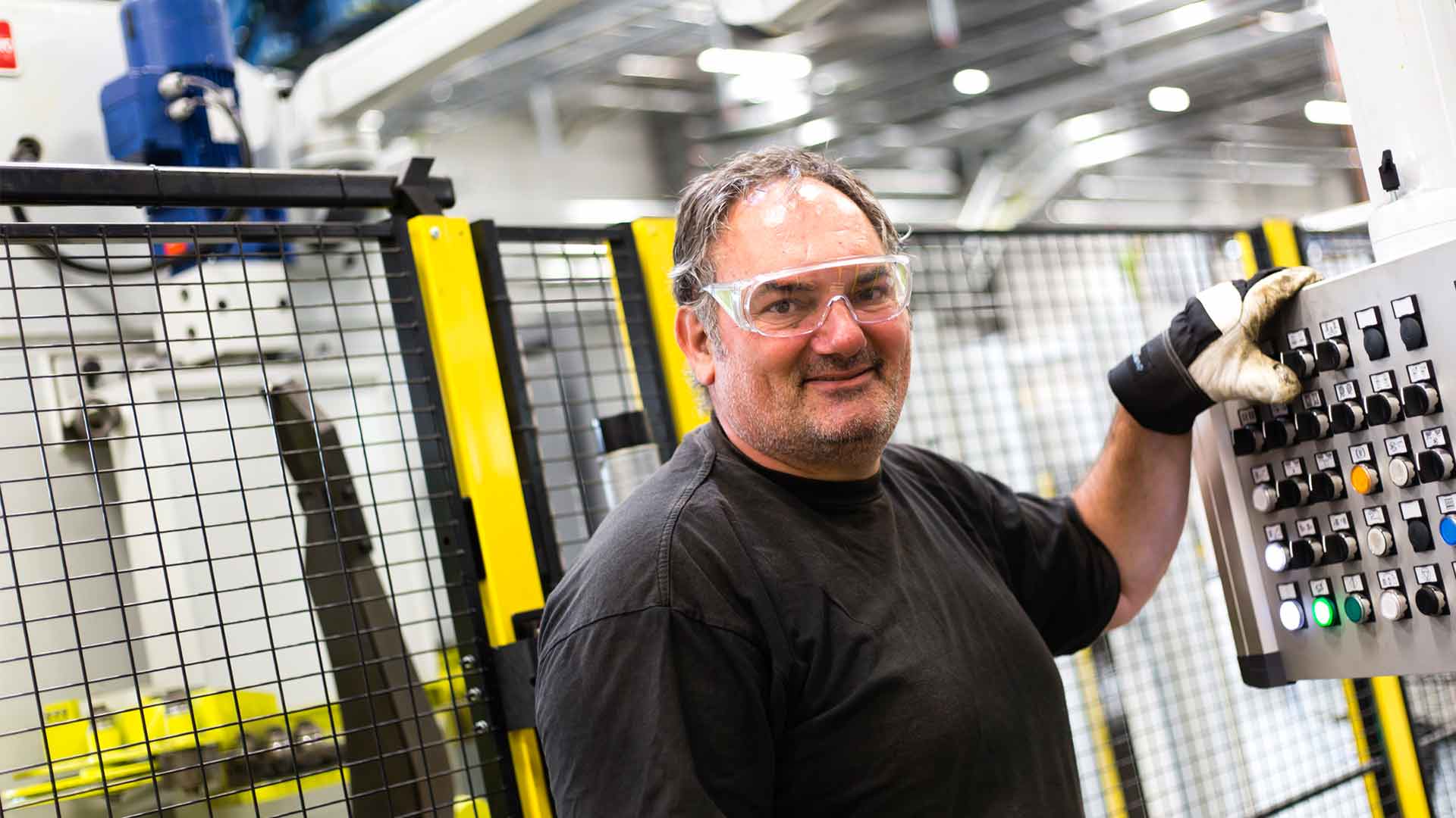 Man operating machine panel infront of Axelent machine guards